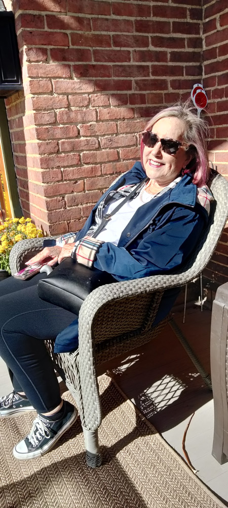 Woman sitting in chair on front porch